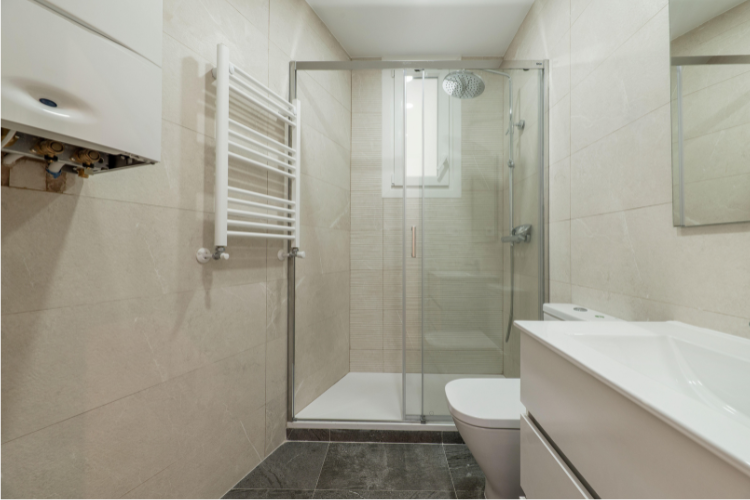 Framed sliding shower door with track system in a compact bathroom