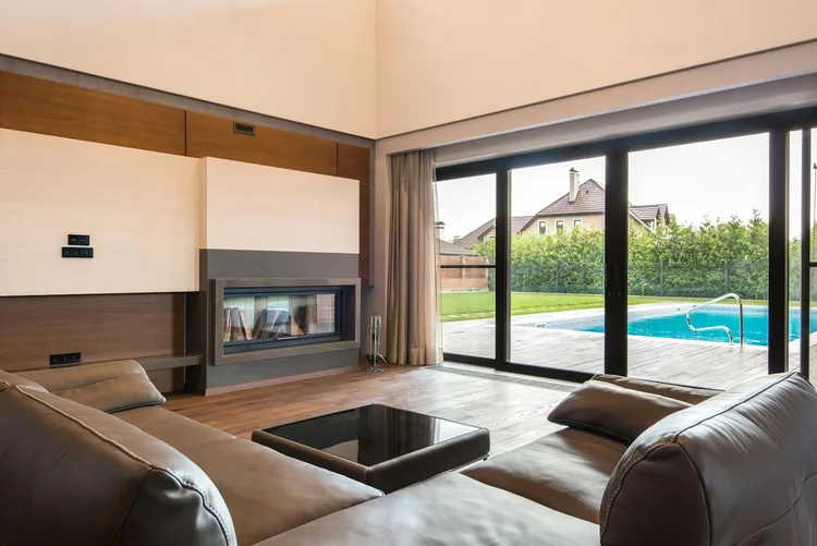 Modern living room with floor-to-ceiling sliding glass doors and impact-rated panels, the upgrade many Broward homeowners pair with window repair