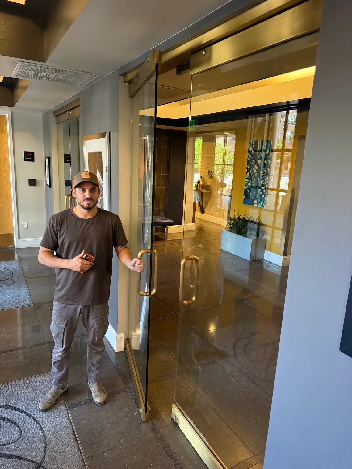 JDM technician at a commercial frameless glass entrance door in Colorado