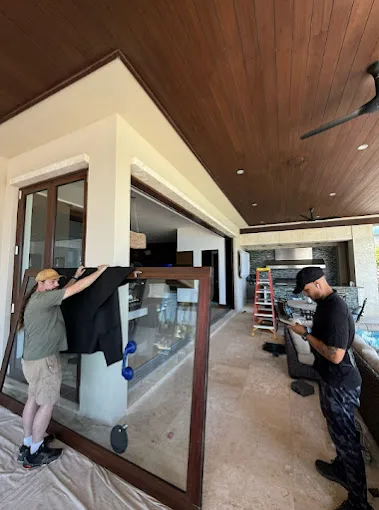 JDM team carrying a large glass door panel at a Florida home