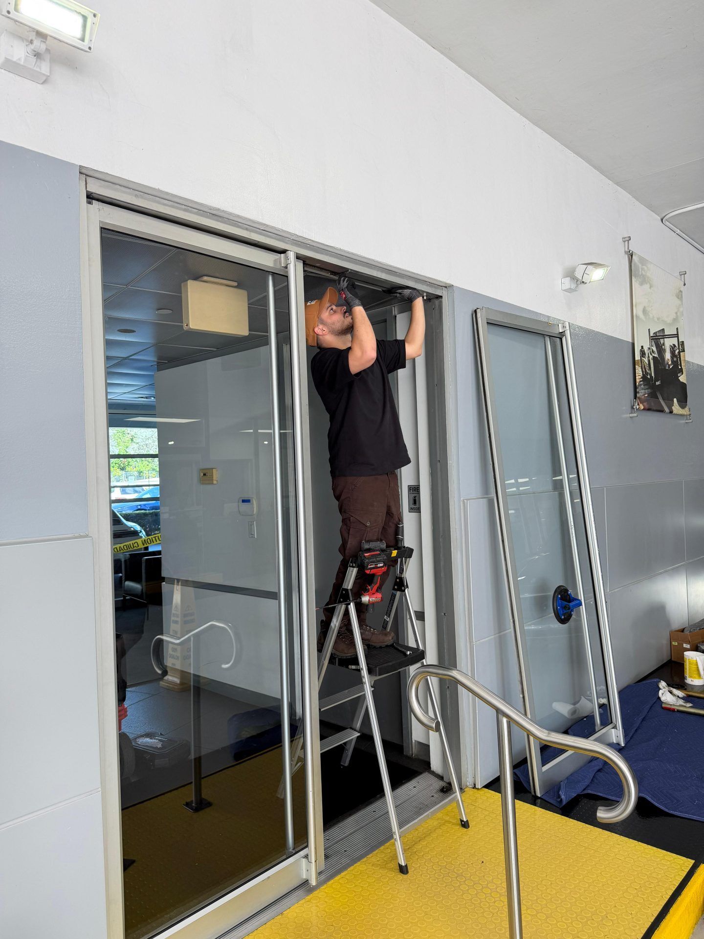 JDM technician sealing and repairing commercial door