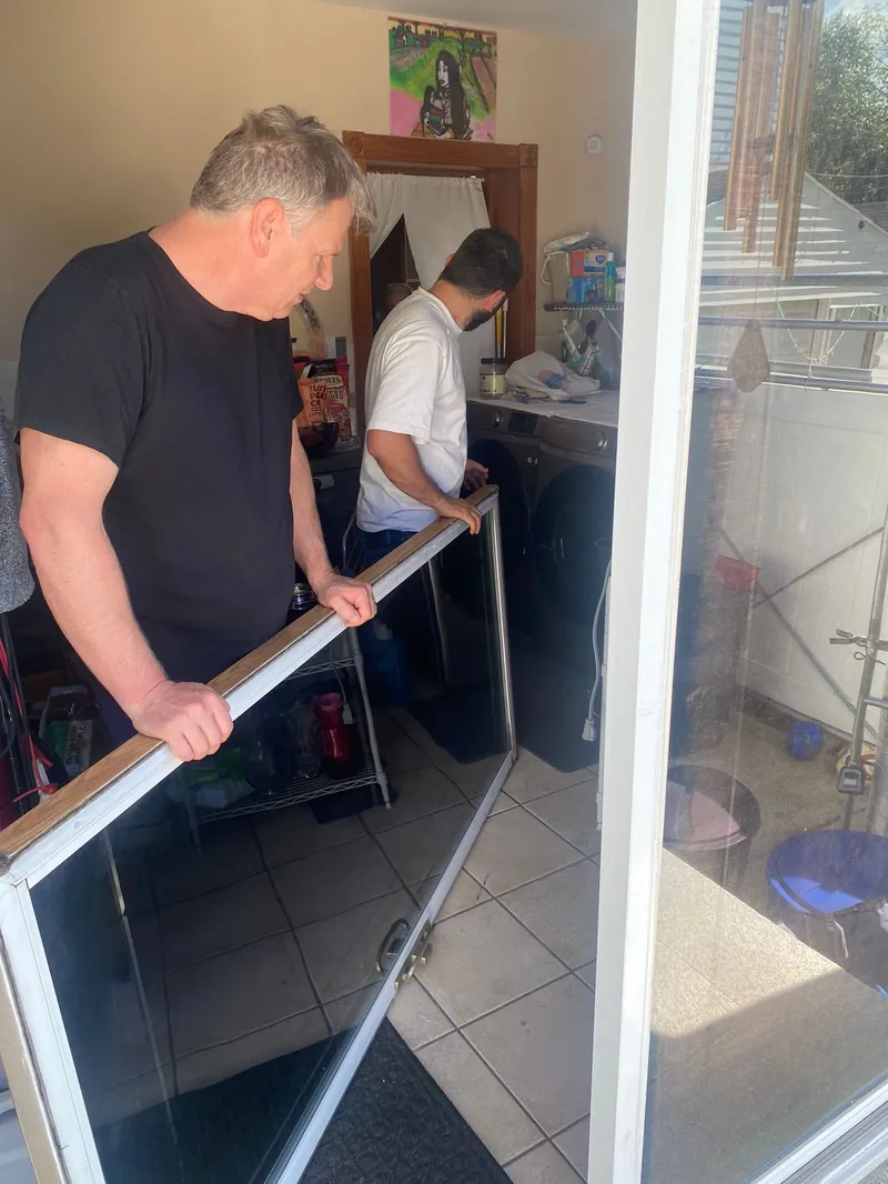 JDM technicians moving a sliding door panel on a Denton County job