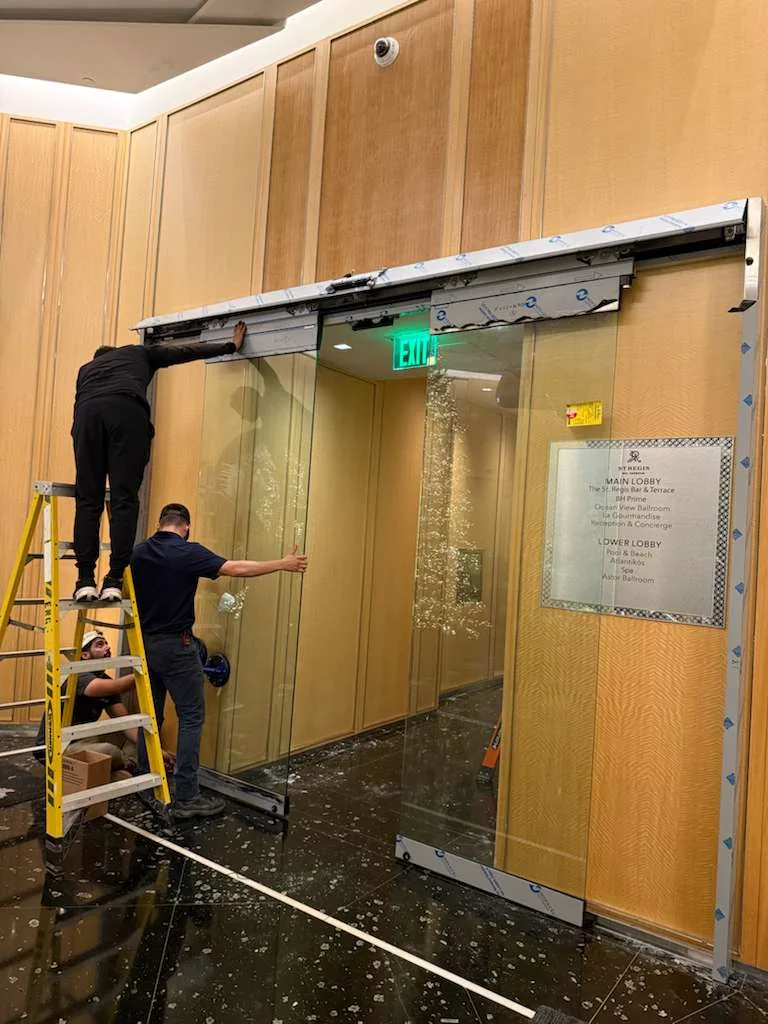 JDM technicians installing an automatic sliding door at a St. Lucie County property